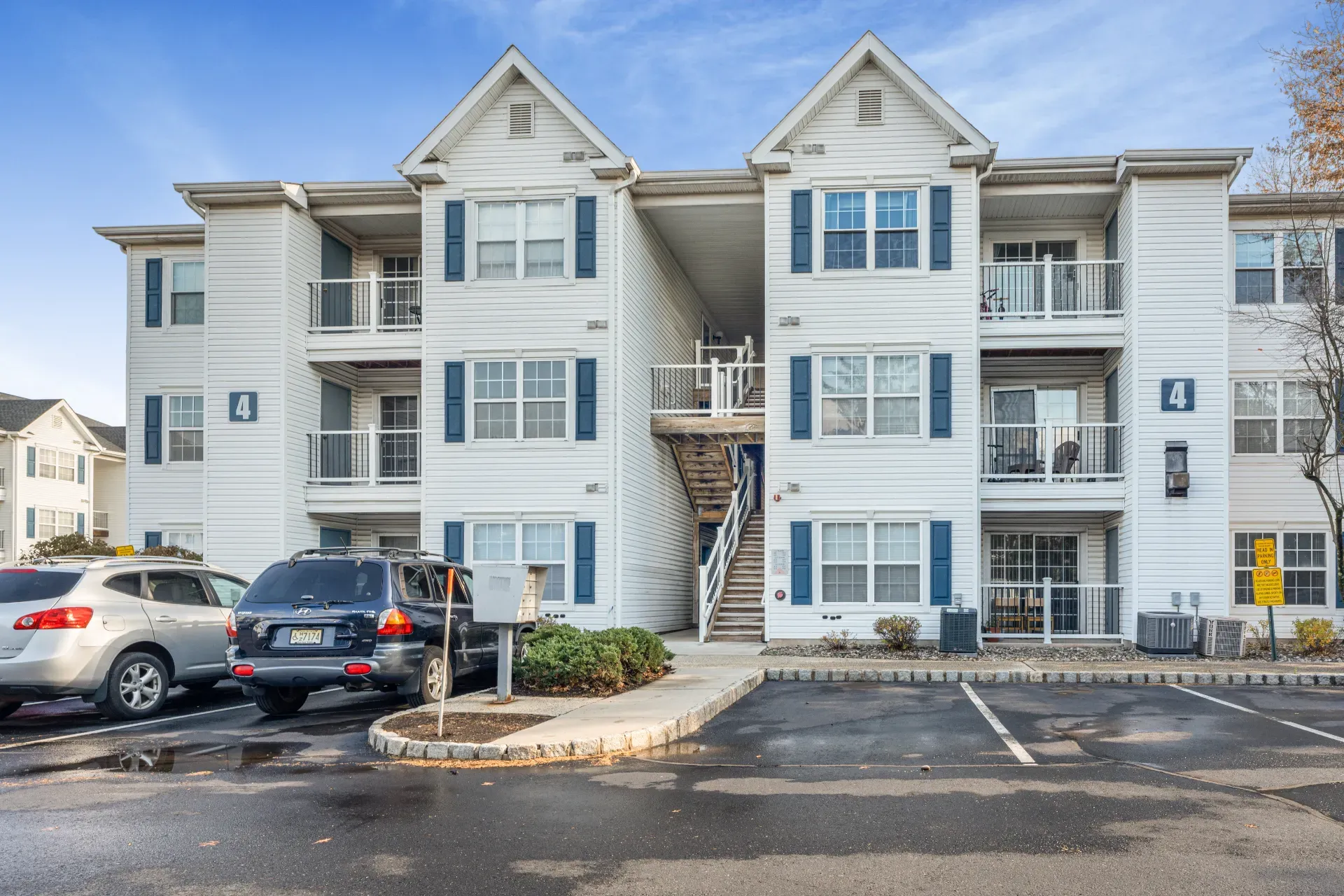 A three-storey garden-apartment building in Edison, New Jersey, seen from its parking court