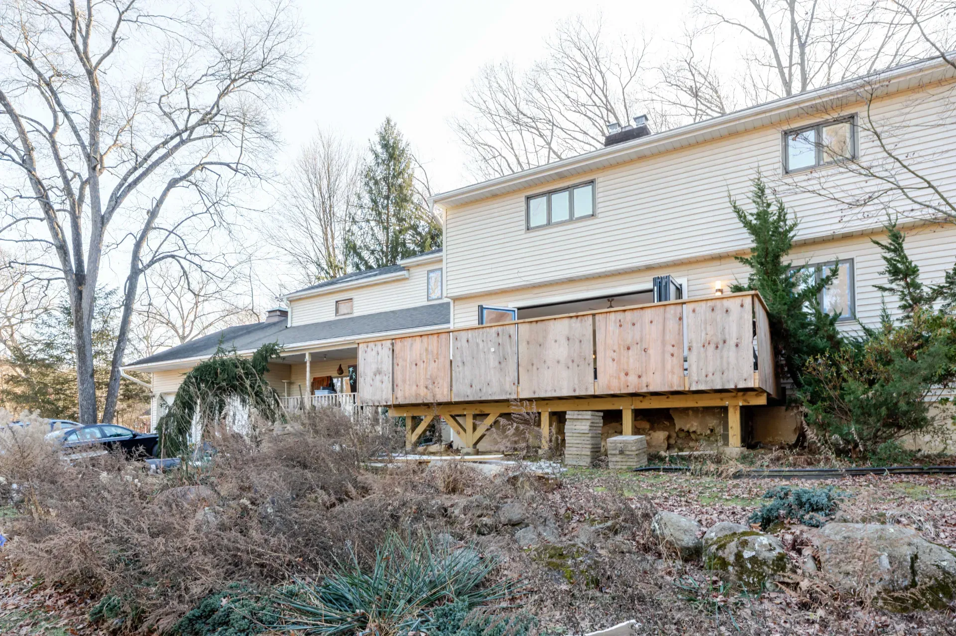 The rear elevation of a house in Port Murray, New Jersey, with a partly built deck on timber posts